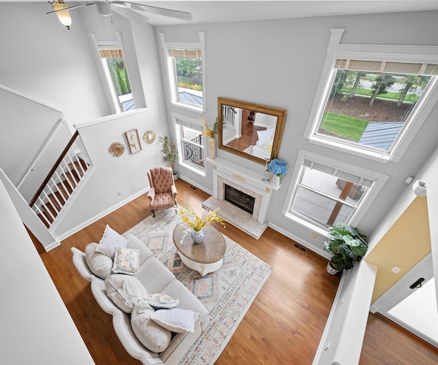 1150 Heatherlea Ct, Canton, MI 48188 - living area featuring ceiling fan, wood finished floors, a high ceiling, a fireplace, and baseboards