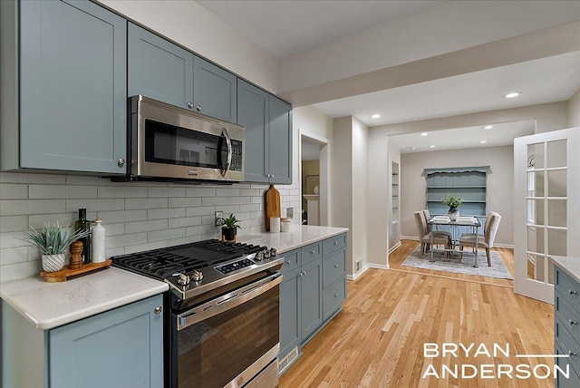 2120 Englewood Dr SE, East Grand Rapids, MI 49506 - kitchen featuring stainless steel appliances, light wood-type flooring, tasteful backsplash, baseboards, and recessed lighting