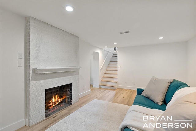 2120 Englewood Dr SE, East Grand Rapids, MI 49506 - living room featuring a fireplace, stairs, wood finished floors, baseboards, and recessed lighting