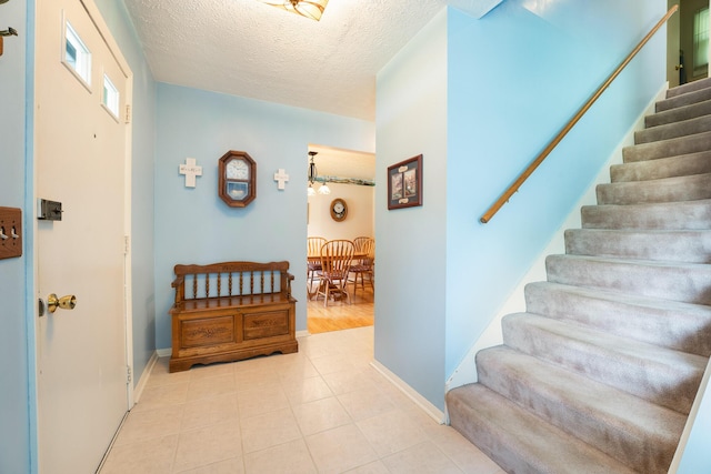 1605 Suffolk Ave, Portage, MI 49024 - foyer with stairs, a textured ceiling, and baseboards
