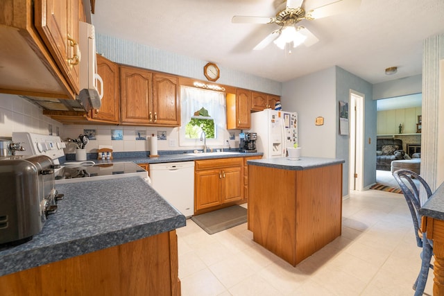1605 Suffolk Ave, Portage, MI 49024 - kitchen featuring white appliances, a kitchen island, dark countertops, a sink, and ceiling fan