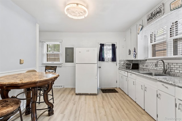 1141 E Madge Ave, Hazel Park, MI 48030 - kitchen with freestanding refrigerator, a sink, electric panel, light wood-style floors, and backsplash