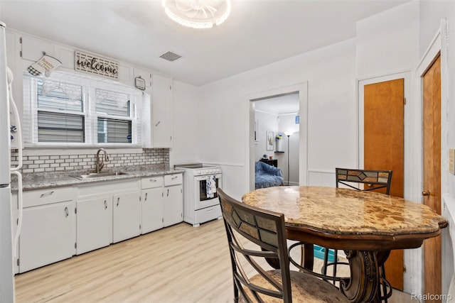 1141 E Madge Ave, Hazel Park, MI 48030 - kitchen with white electric range, a sink, light wood-style flooring, light countertops, and tasteful backsplash