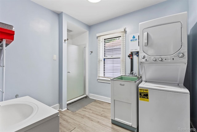 1141 E Madge Ave, Hazel Park, MI 48030 - laundry area featuring stacked washer and clothes dryer, light wood-type flooring, baseboards, and a sink