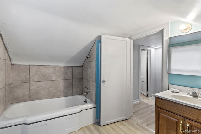 1141 E Madge Ave, Hazel Park, MI 48030 - bathroom with vaulted ceiling, wood finished floors, vanity, and bathing tub / shower combination
