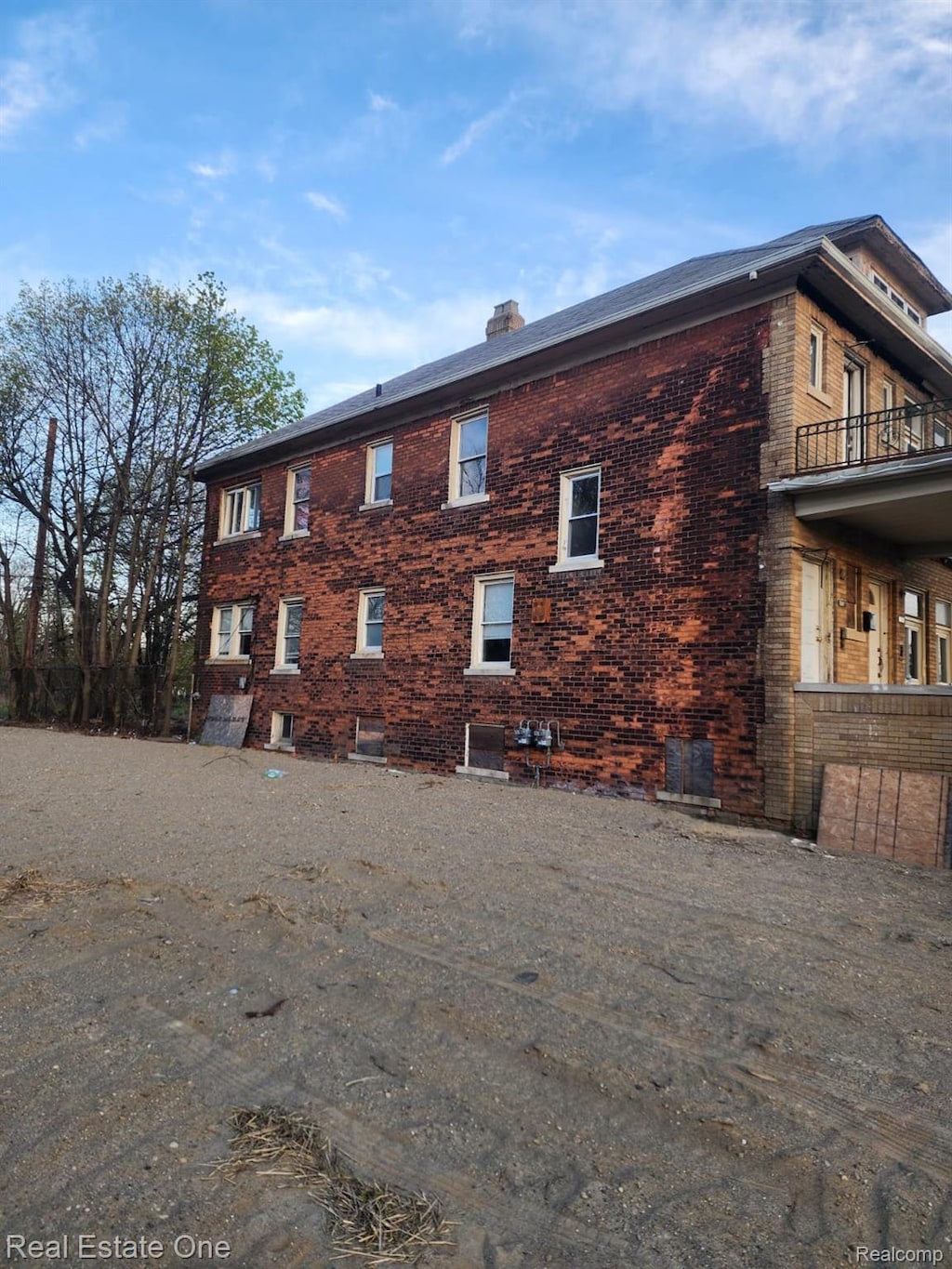 8450 Maxwell St, Detroit, MI 48213 - view of property exterior with brick siding, a chimney, and a balcony