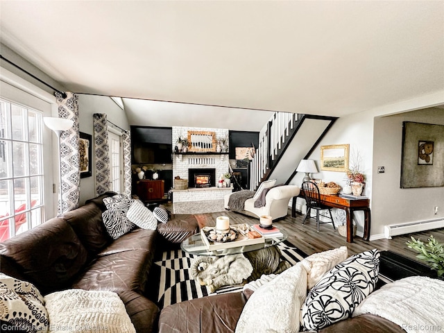 2109 S Lakeshore Rd, Harbor Beach, MI 48441 - living room featuring baseboard heating, wood finished floors, a fireplace, baseboards, and stairs