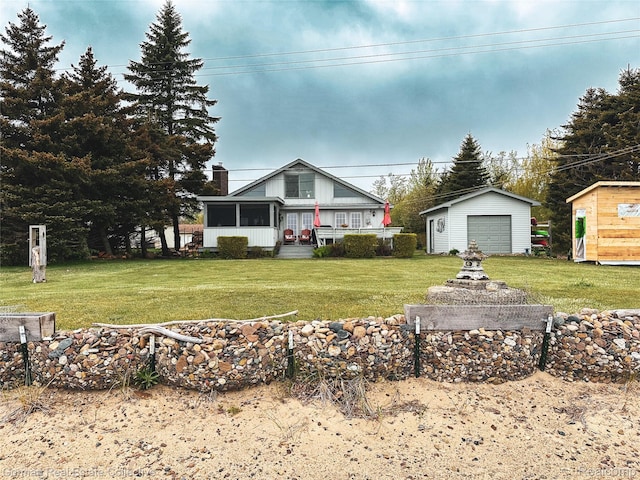 2109 S Lakeshore Rd, Harbor Beach, MI 48441 - view of front of house with an outdoor structure, a front yard, a sunroom, and a garage