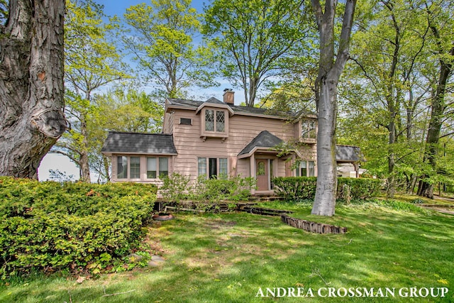 5011 Rosabelle Beach Ave, Holland, MI 49424 - view of front facade with a chimney and a front yard
