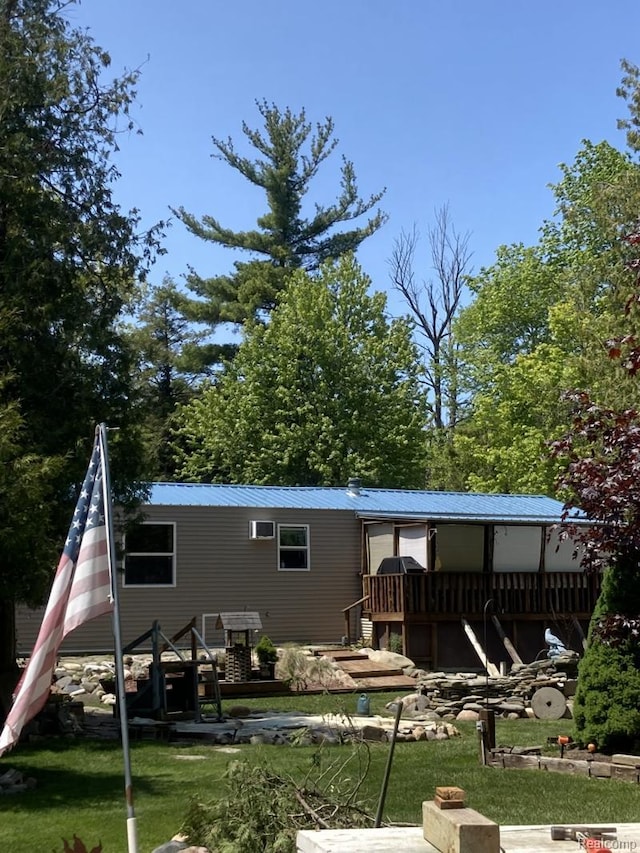2999 Copeland Rd, Port Austin, MI 48467 - rear view of house featuring metal roof, a wooden deck, and a yard