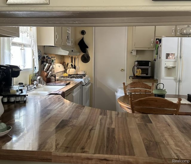 2999 Copeland Rd, Port Austin, MI 48467 - kitchen featuring white appliances, a sink, light countertops, white cabinetry, and under cabinet range hood