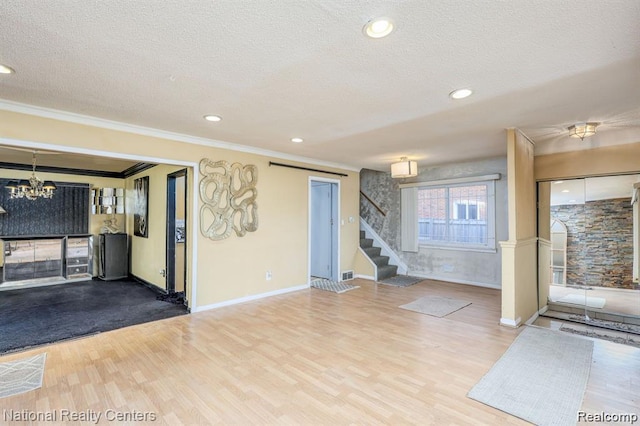 29249 Everett St, Southfield, MI 48076 - unfurnished living room featuring stairs, ornamental molding, a textured ceiling, a chandelier, and wood finished floors