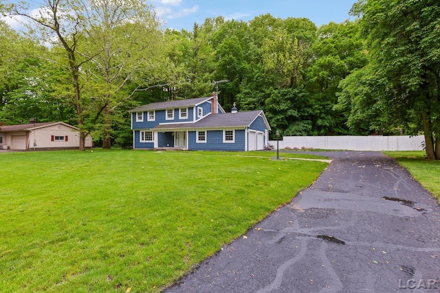 1706 Southgate Ct, Adrian, MI 49221 - colonial house featuring a chimney, covered porch, a garage, and driveway