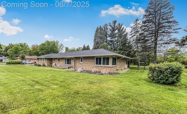 2211 N Sycamore Dr, Burton, MI 48509 - view of front of home with a front yard, brick siding, and view of scattered trees