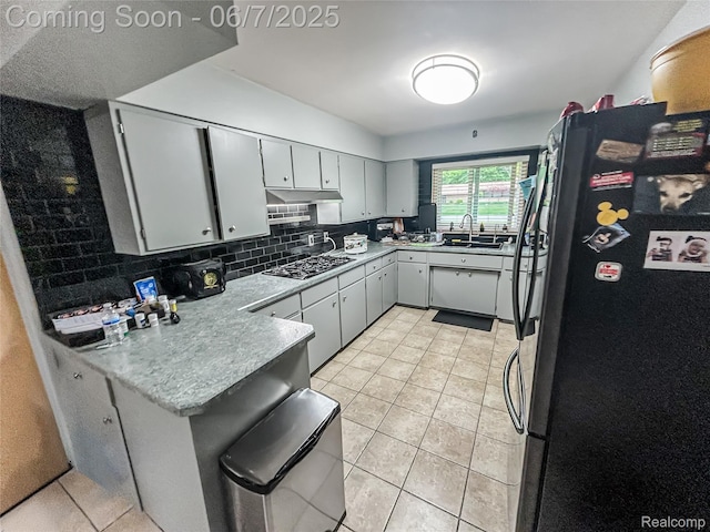 2211 N Sycamore Dr, Burton, MI 48509 - kitchen featuring freestanding refrigerator, gas stovetop, a sink, a peninsula, and light tile patterned floors
