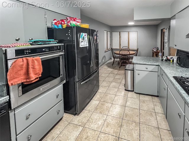 2211 N Sycamore Dr, Burton, MI 48509 - kitchen with light tile patterned floors, black appliances, light countertops, and a peninsula