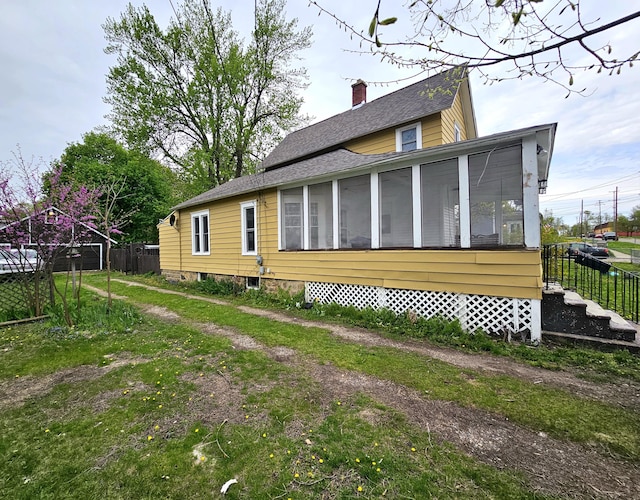 228 Meachem Ave, Battle Creek, MI 49015 - back of property featuring a sunroom, a chimney, and roof with shingles