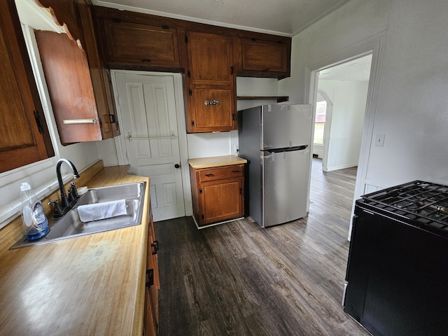 228 Meachem Ave, Battle Creek, MI 49015 - kitchen with freestanding refrigerator, black gas range oven, a sink, dark wood-style flooring, and light countertops
