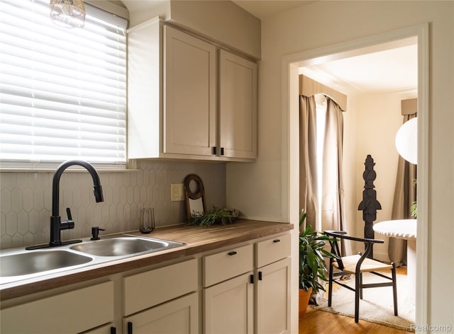 16230 Santa Rosa Dr, Detroit, MI 48221 - kitchen featuring a sink, light wood-style floors, decorative backsplash, butcher block counters, and white cabinetry