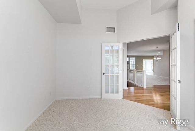 2632 E Turning Leaf Way Unit 111, Fruitport, MI 49415 - spare room featuring a chandelier, baseboards, and carpet