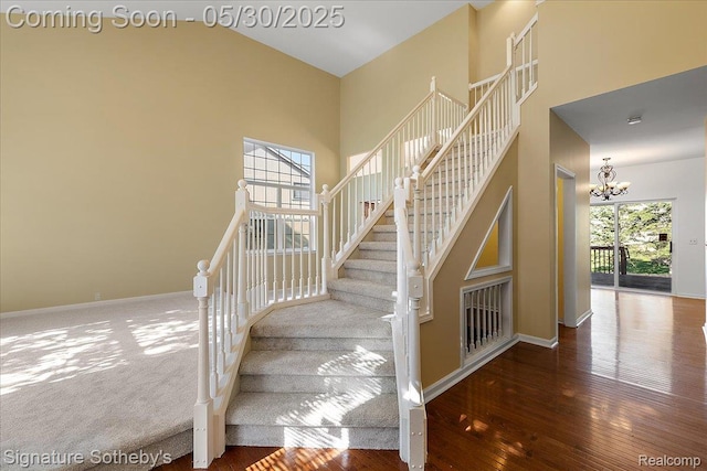 31190 Kingsley Ct, Novi, MI 48377 - stairway featuring a chandelier, hardwood / wood-style floors, and a high ceiling