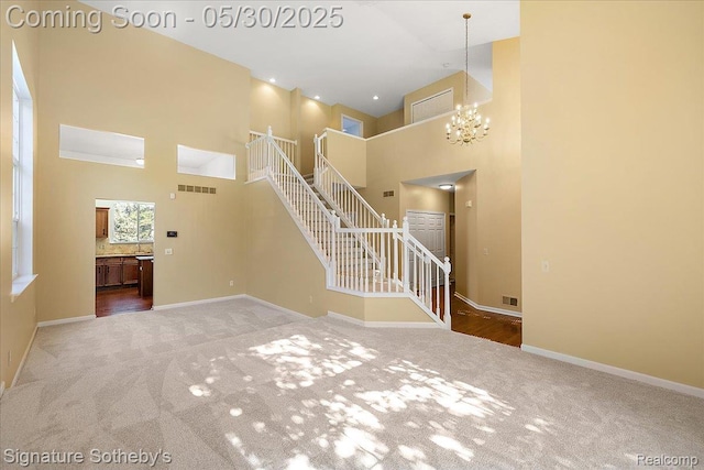 31190 Kingsley Ct, Novi, MI 48377 - unfurnished living room featuring a towering ceiling, carpet floors, a chandelier, and stairs