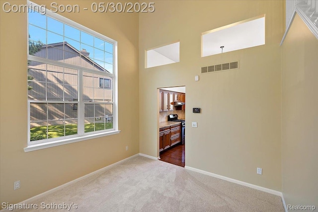 31190 Kingsley Ct, Novi, MI 48377 - empty room with dark colored carpet, healthy amount of natural light, and a towering ceiling