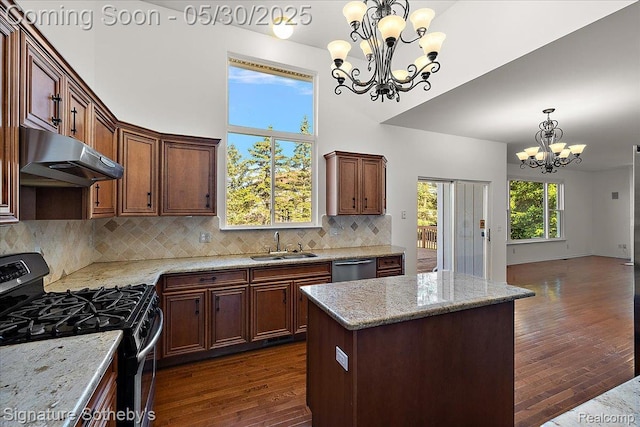 31190 Kingsley Ct, Novi, MI 48377 - kitchen featuring black gas stove, a chandelier, under cabinet range hood, dark wood-type flooring, and backsplash