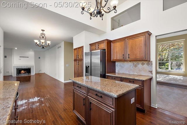31190 Kingsley Ct, Novi, MI 48377 - kitchen featuring stainless steel fridge, a chandelier, dark wood-type flooring, open floor plan, and hanging light fixtures
