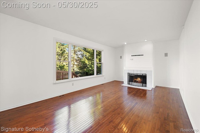 31190 Kingsley Ct, Novi, MI 48377 - unfurnished living room featuring hardwood / wood-style flooring and a tiled fireplace