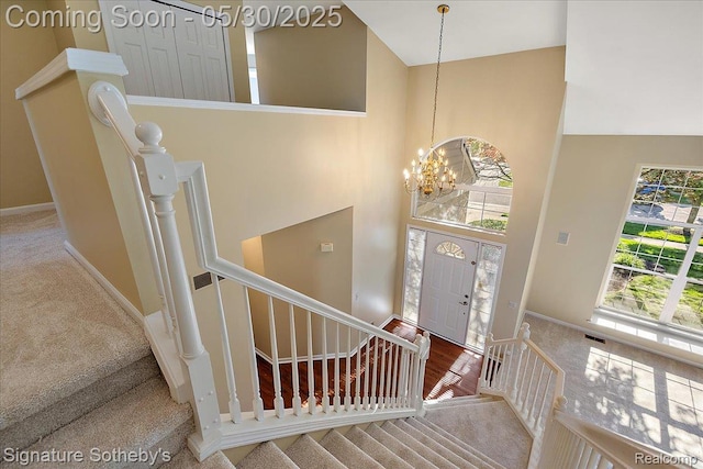 31190 Kingsley Ct, Novi, MI 48377 - carpeted foyer entrance featuring high vaulted ceiling, a chandelier, and stairs