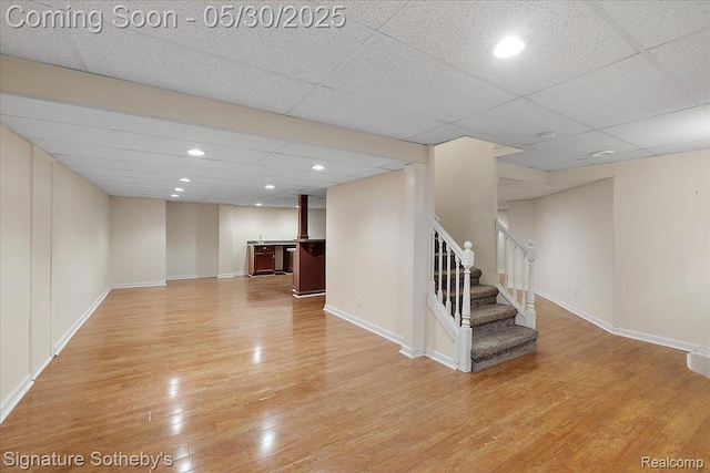 31190 Kingsley Ct, Novi, MI 48377 - unfurnished living room with stairs, light wood-type flooring, a paneled ceiling, bar area, and recessed lighting