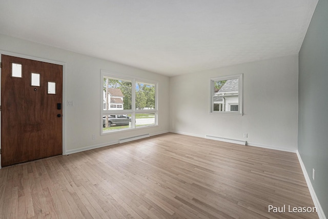1043 Eastern Ave NE, Grand Rapids, MI 49503 - entrance foyer featuring a baseboard radiator, light wood-style floors, healthy amount of natural light, and baseboards