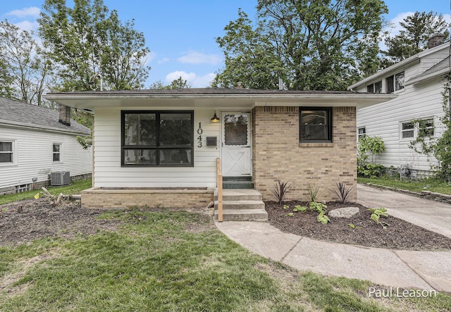 1043 Eastern Ave NE, Grand Rapids, MI 49503 - view of front of property with entry steps, brick siding, cooling unit, and a front yard