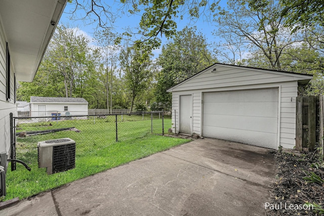 1043 Eastern Ave NE, Grand Rapids, MI 49503 - detached garage with central AC, driveway, and view of wooded area