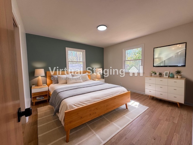 1043 Eastern Ave NE, Grand Rapids, MI 49503 - bedroom with light wood-style floors, multiple windows, and baseboards