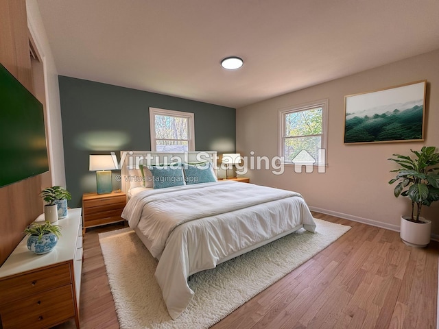 1043 Eastern Ave NE, Grand Rapids, MI 49503 - bedroom with multiple windows, wood finished floors, and baseboards