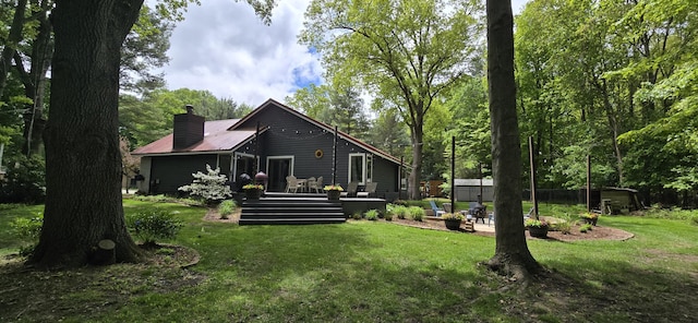 4447 Deer Creek Dr, Norton Shores, MI 49441 - back of house with a lawn, a wooden deck, a chimney, and metal roof