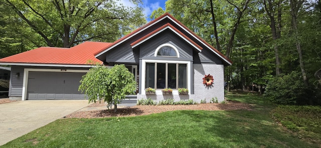 4447 Deer Creek Dr, Norton Shores, MI 49441 - view of front of house featuring an attached garage, a front lawn, driveway, brick siding, and metal roof