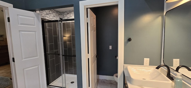 4447 Deer Creek Dr, Norton Shores, MI 49441 - bathroom with vanity, a stall shower, toilet, and marble look tile flooring