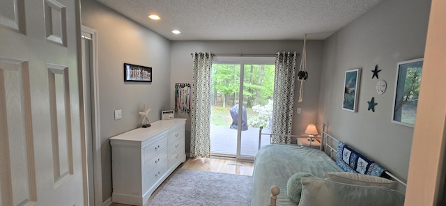 4447 Deer Creek Dr, Norton Shores, MI 49441 - bedroom with access to exterior, a textured ceiling, wood finished floors, and recessed lighting