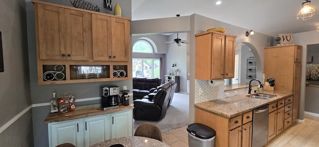 4447 Deer Creek Dr, Norton Shores, MI 49441 - kitchen featuring a sink, stainless steel dishwasher, light stone counters, arched walkways, and a ceiling fan
