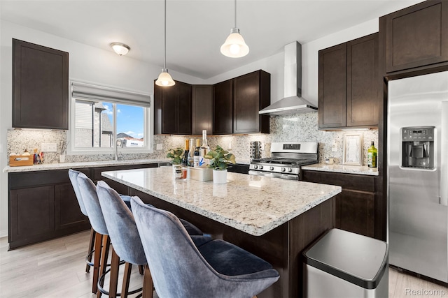 52690 Char Marie, Macomb, MI 48042 - kitchen featuring appliances with stainless steel finishes, wall chimney range hood, a kitchen island, dark brown cabinets, and light stone counters