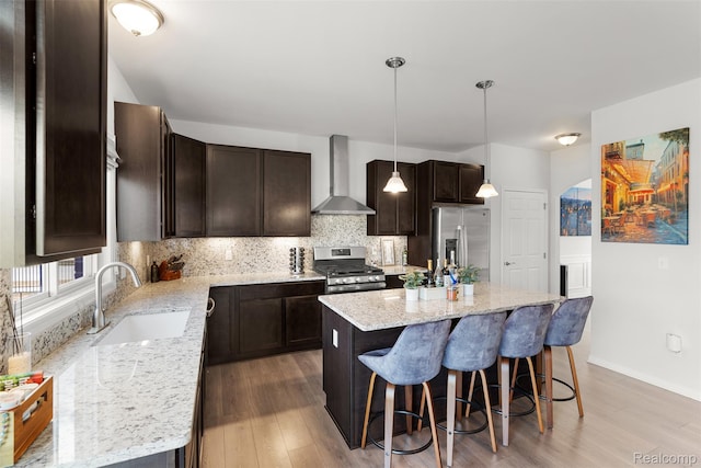 52690 Char Marie, Macomb, MI 48042 - kitchen with wall chimney exhaust hood, a sink, appliances with stainless steel finishes, dark brown cabinetry, and light wood-style floors