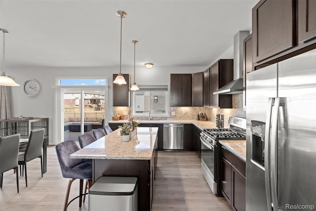 52690 Char Marie, Macomb, MI 48042 - kitchen with stainless steel appliances, dark brown cabinetry, wall chimney range hood, backsplash, and light wood-style floors