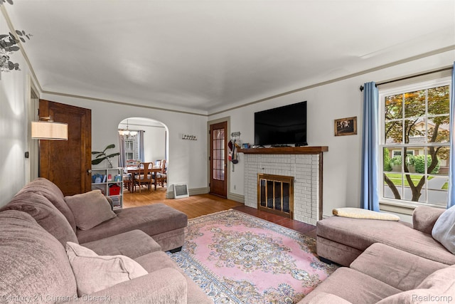 34642 Elm St, Wayne, MI 48184 - living area featuring wood finished floors, arched walkways, a brick fireplace, and a chandelier