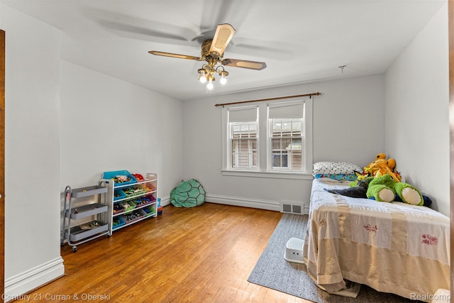 34642 Elm St, Wayne, MI 48184 - bedroom with wood finished floors, a baseboard radiator, and ceiling fan