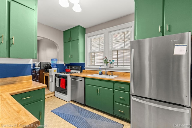 34642 Elm St, Wayne, MI 48184 - kitchen with appliances with stainless steel finishes, light flooring, arched walkways, and butcher block counters