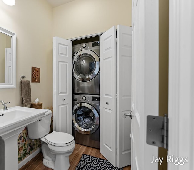 5702 Copper Sands Run Unit 101, Fruitport, MI 49415 - bathroom with stacked washer / dryer, wood finished floors, and toilet