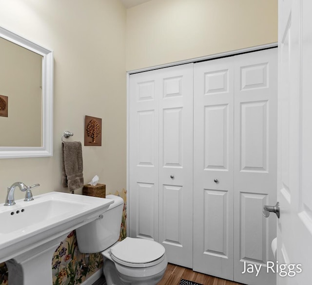 5702 Copper Sands Run Unit 101, Fruitport, MI 49415 - bathroom with toilet, a closet, wood finished floors, and a sink
